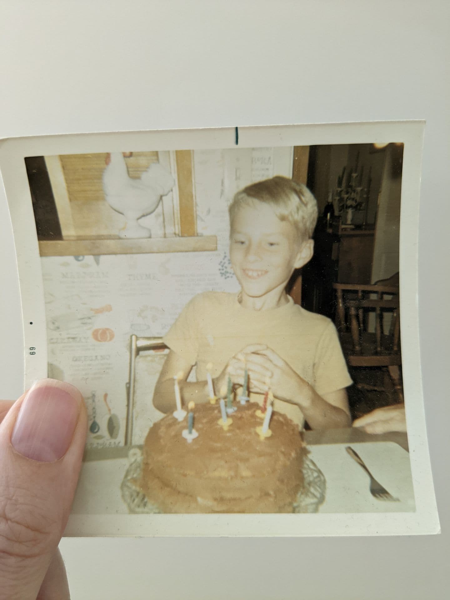 Rowe at age eight, grinning at a birthday cake covered in candles